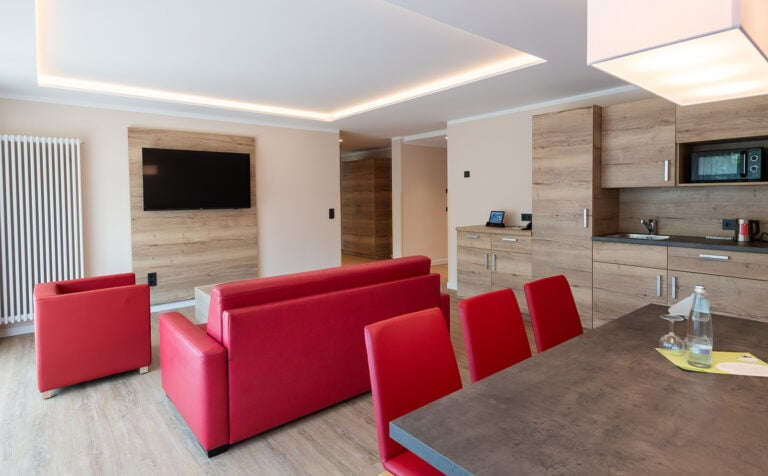 großer Wohnraum mit kleiner Küche in Suite des Rhön Park Aktiv Resorts